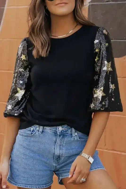 Close-up of Black Star Sequin Top highlighting gold and silver star sequins on wide half sleeves, ideal for event wear.