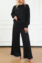 Women's black textured loungewear set with slouchy fit, featuring wide-leg pants and long-sleeve top for cozy casual wear.