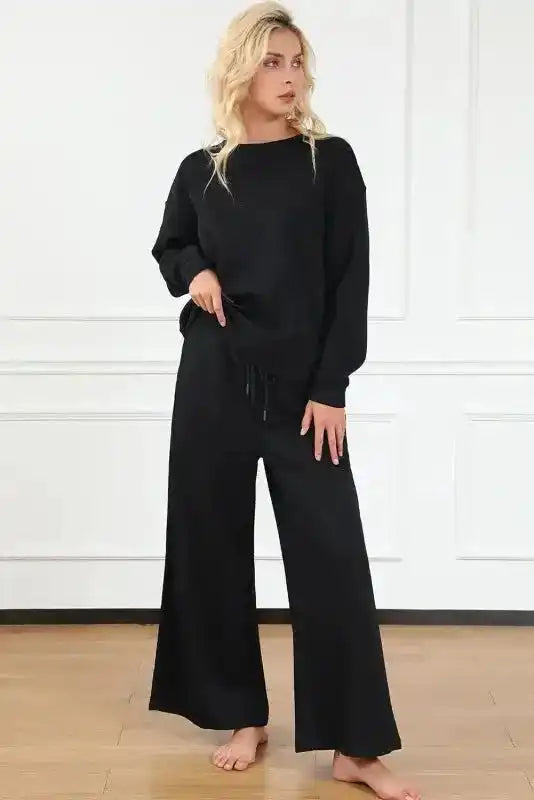 Textured black 2-piece loungewear set for women featuring wide-leg pants and a relaxed pullover top for stylish comfort at home.