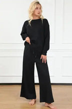 Textured black 2-piece loungewear set for women featuring wide-leg pants and a relaxed pullover top for stylish comfort at home.