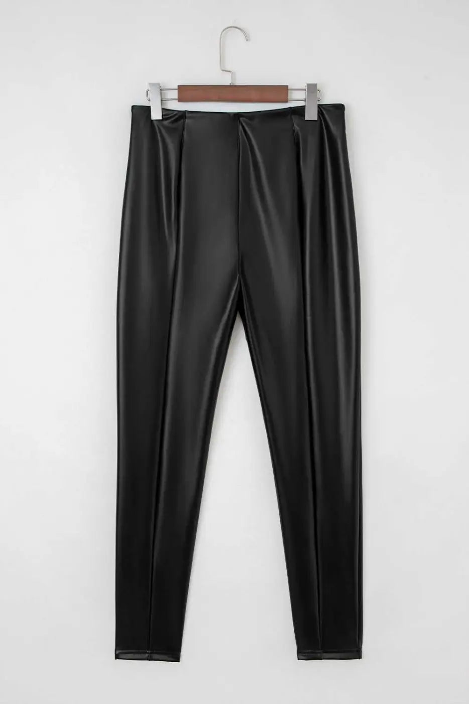 Back view of Black Vegan Leather Leggings – High‑Rise Skinny Fit on hanger, displaying smooth PU leather and high-rise waistband.