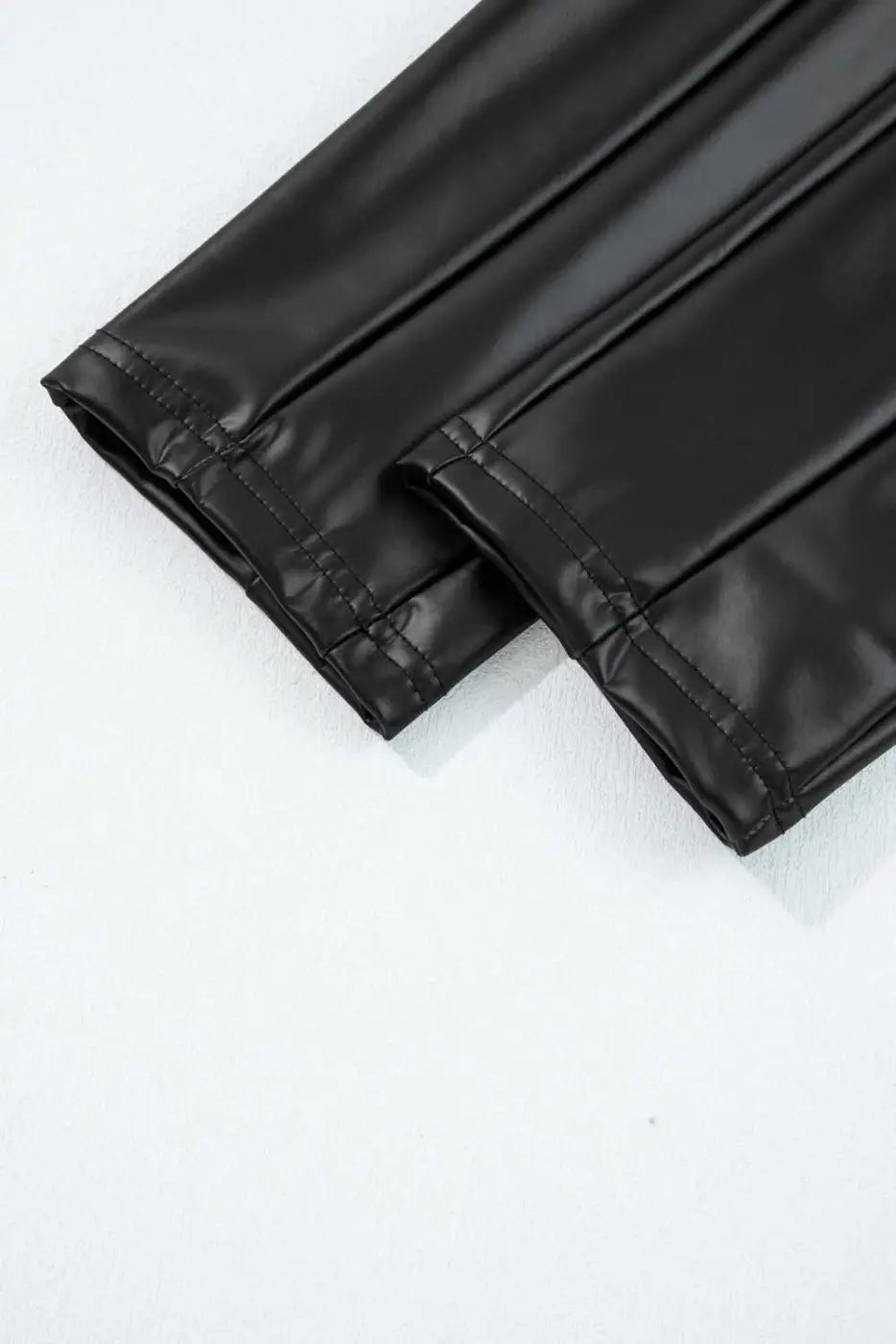 Detailed view of ankle hem stitching on Black Vegan Leather Leggings – High‑Rise Skinny Fit, showcasing durable finish and sleek cut.