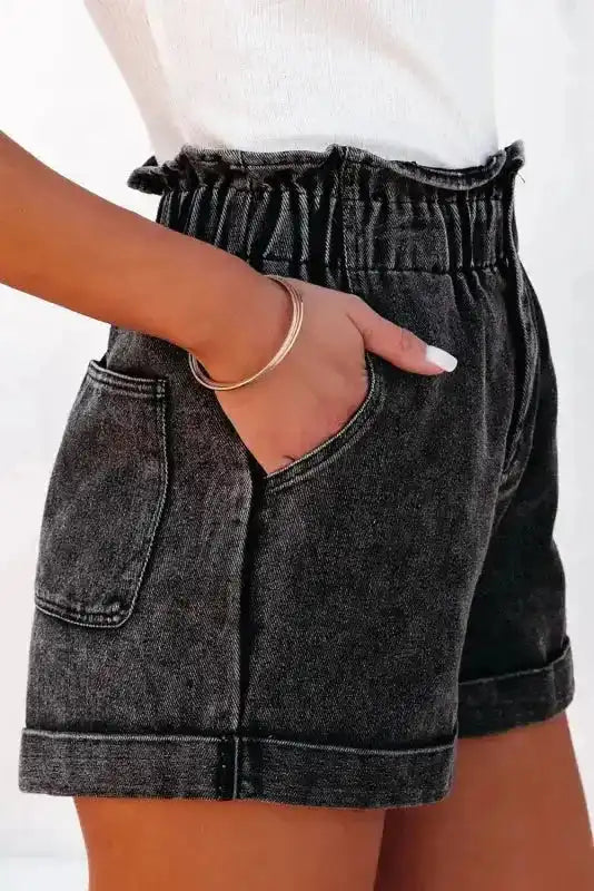 Side view of black vintage washed denim shorts featuring high waist frilled hem and deep front pockets, ideal for casual summer outfits.