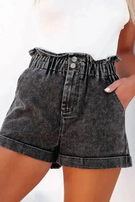 Close-up front view of ladies black vintage washed denim shorts with double button closure and frilled high waist design.