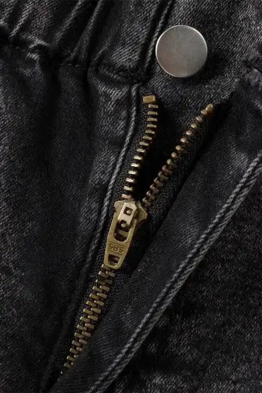Close-up of zipper and button fly on black vintage washed denim shorts, showcasing quality hardware and construction.