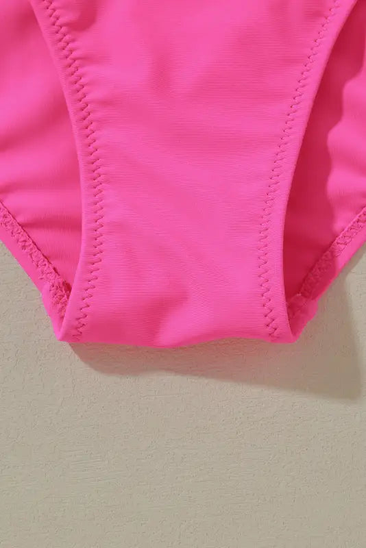 Bright pink rose red swimsuit bottom with visible stitching and deep v neck detail