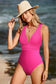 Woman in rose red deep v neck monokini relaxing at beach with wide-brimmed sun hat