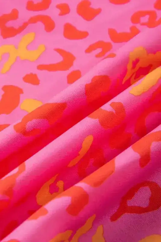 Fabric detail of Wild in Pink Leopard Blouse showing soft texture and vivid pink, orange, and yellow leopard print. Ideal for casual summer wear.
