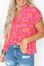 Wild in Pink leopard blouse with V-neck and short sleeves styled with distressed denim shorts. Bold pink and orange print for casual summer looks.