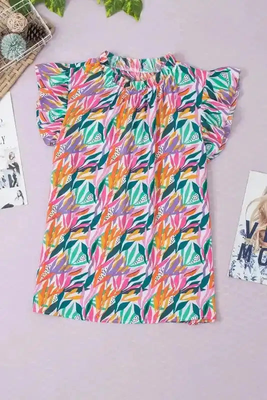 Flat lay of Pink Floral Flutter Sleeve Blouse showcasing bold floral print and lightweight material for spring and summer wear.