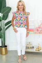 Full outfit featuring Pink Floral Flutter Sleeve Blouse paired with white pants and sandals, perfect for casual summer occasions.