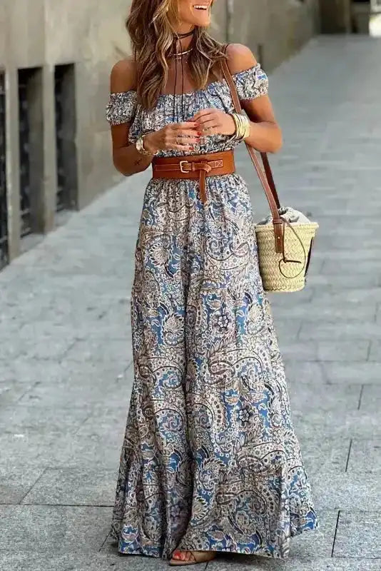 Blue Boho Paisley Maxi Dress - Off Shoulder Bardot style with A-line silhouette, styled with a brown belt and straw bag for summer fashion.
