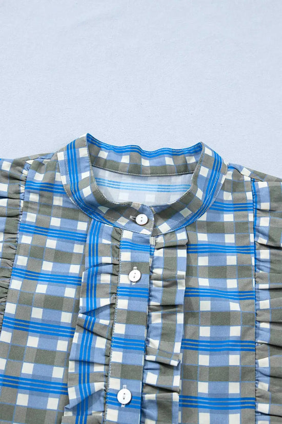Close-up of blue plaid long sleeve frilled blouse showing front button placket and ruffled detailing on soft cotton fabric.