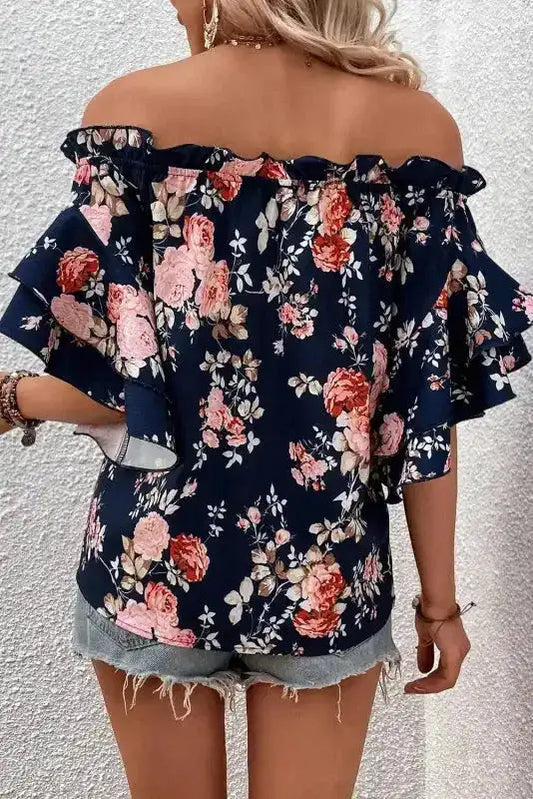 Back view of blue floral off‑shoulder blouse featuring ruffle and flounce sleeves, perfect for summer outings and casual wear.