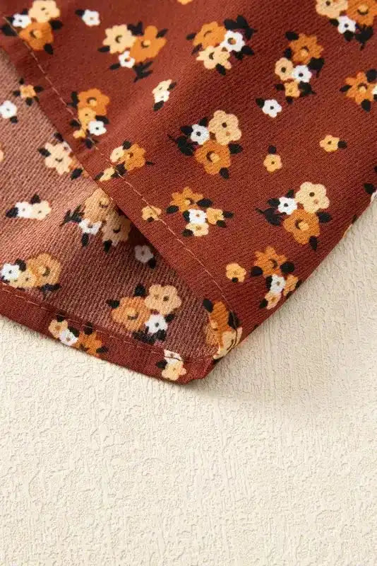 Hem detail of Boho Floral Peplum Blouse, highlighting stitching and floral fabric in rust brown tones.