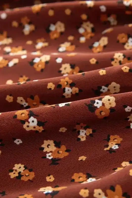 Fabric close-up of Boho Floral Peplum Blouse, showcasing soft texture and whimsical floral pattern in warm tones.