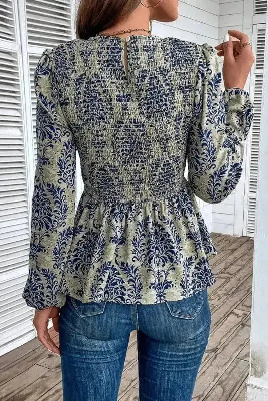 Back view of Floral Smocked Peplum Balloon Sleeve Blouse showing long balloon sleeve structure and peplum silhouette — Fashionfitz