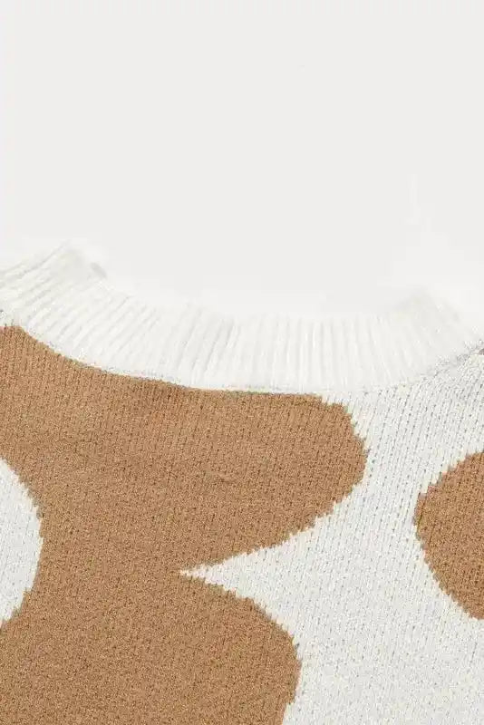 Detailed view of sweater shoulder area highlighting the smooth transition of beige floral pattern on soft knit fabric.