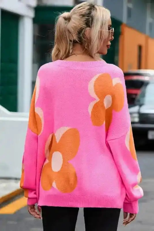 Back view of Bonbon Plus floral sweater in urban setting, showcasing bold flower graphics and relaxed fit for fall wear.