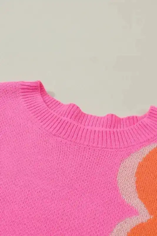 Close-up of Bonbon Plus floral sweater neckline, showing ribbed knit collar and vibrant pink fabric with orange floral detail.