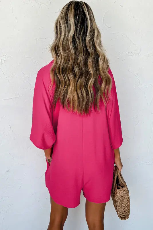 Relax relax in the bright pink romper with three-quarter sleeves and collared button detail