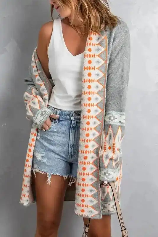 Open-front Gray Aztec Print Cardigan with warm earthy tones and geometric design, styled casually with denim shorts.