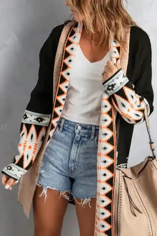 Brown Aztec Print Cardigan in black with tribal patterns, styled open over a white top and denim shorts for a bohemian fall look.