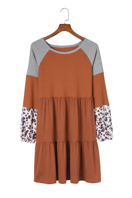 Brown waffle knit dress with gray raglan sleeves and leopard print cuffs on hanger