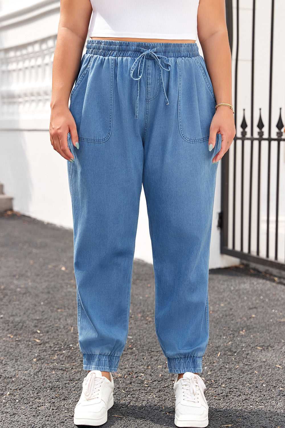 Front view of Plus Size Blue Denim Joggers with drawstring waist and oversized front pockets, perfect for casual fall outings.