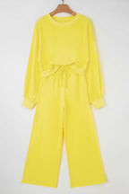 Flat lay of yellow Drop Crop Wide-Leg Pants Set on hanger, featuring cropped sweatshirt and wide-leg pants for casual wear.