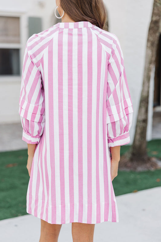 Person wearing a pink and white striped dress with a blurred background