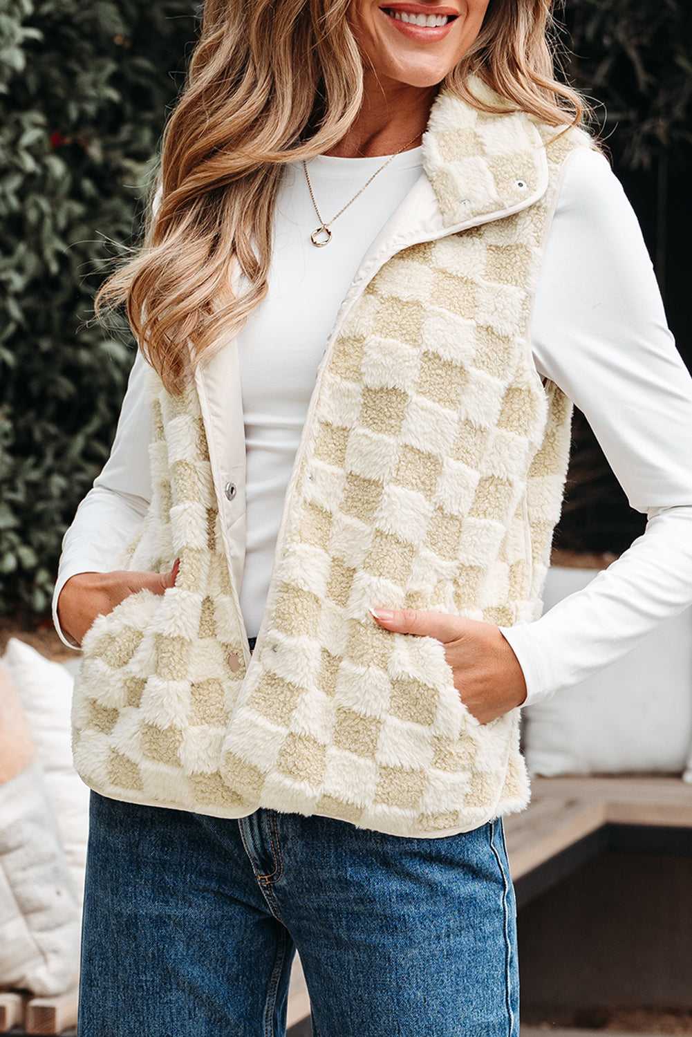 Woman wearing a Sherpa Fleece Vest over a white shirt with blue jeans.