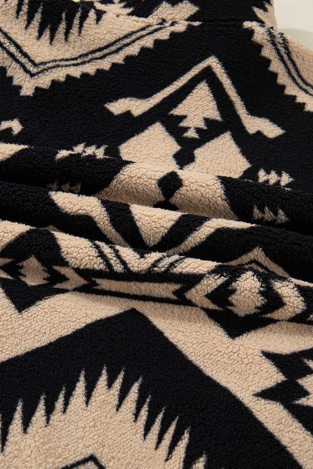 Detailed view of sherpa fleece fabric on Women's Black Plus Size Aztec Print Plush Sweatshirt, showcasing soft texture and bold print.
