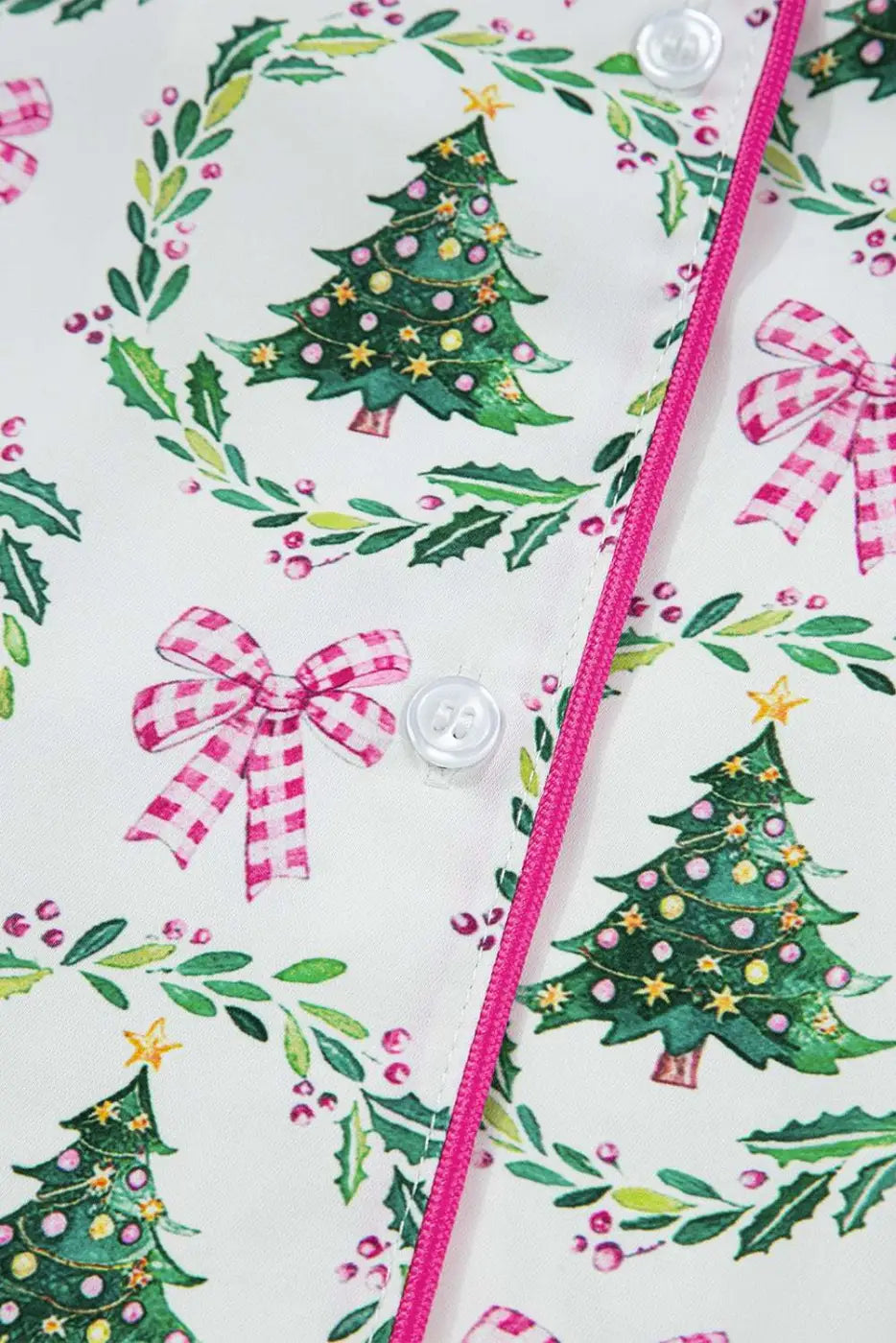 Detail of button placket on Ladies White Christmas Print Velvet Trim Pyjamas with pink piping and festive tree and bow design.