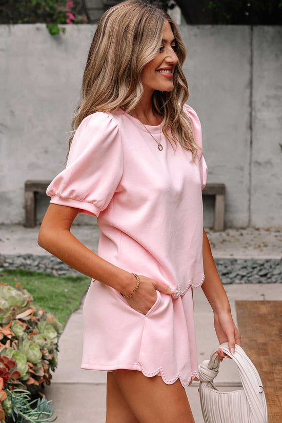 Woman wearing a pink skort set  standing outdoors with a neutral background