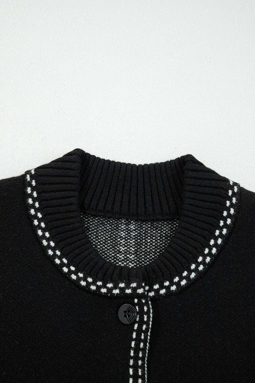 Close-up of ribbed neckline on Women's Black Contrast Trim Knitted Cardigan with white stitched trim for a polished finish.