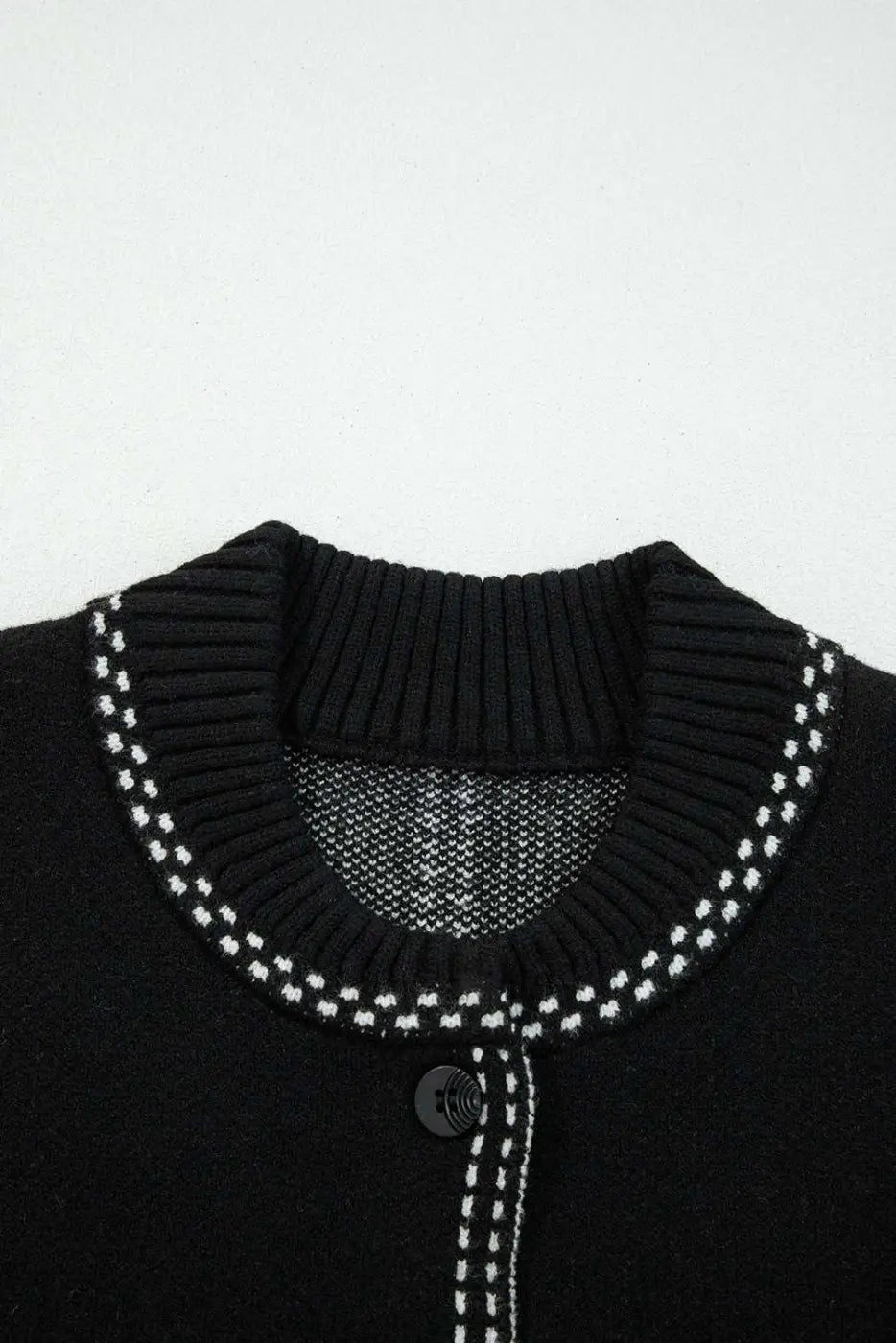 Close-up of ribbed neckline on Women's Black Contrast Trim Knitted Cardigan with white stitched trim for a polished finish.