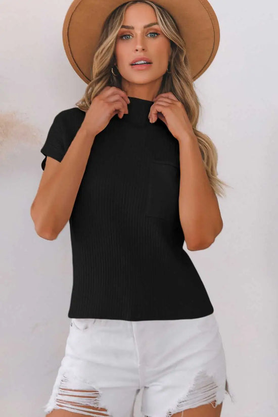 Front view of woman wearing black ribbed knit short sleeve sweater with mock neck and chest pocket, styled for casual elegance.