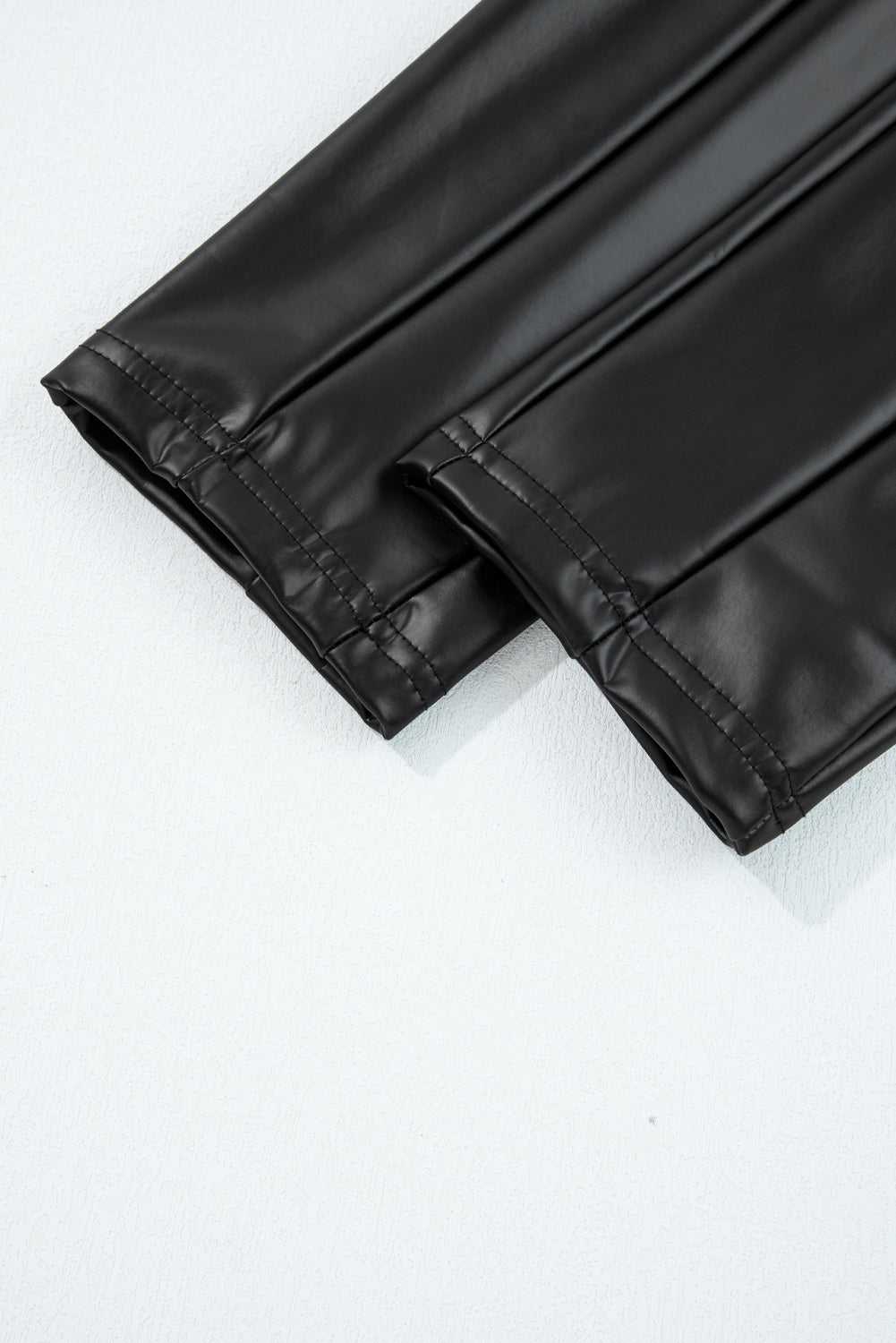 Detailed view of ankle hem stitching on Black Vegan Leather Leggings – High‑Rise Skinny Fit, showcasing durable finish and sleek cut.