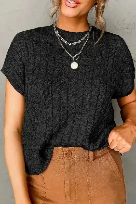 Black Cable Knit Short Sleeve Sweater styled with tan pants, showcasing a versatile, lightweight knit top for transitional seasons.
