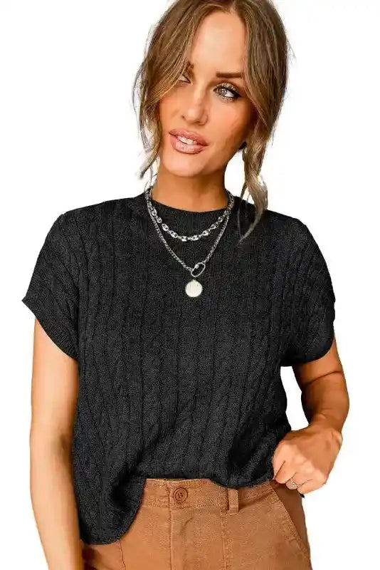 Studio view of black Cable Knit Short Sleeve Sweater on model, showcasing its soft texture and classic crew neck design for women’s knitwear.