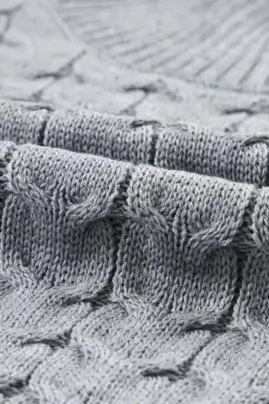Close-up of grey cable knit texture and ribbed turtleneck. Soft acrylic fabric ideal for layering in fall and winter seasons.