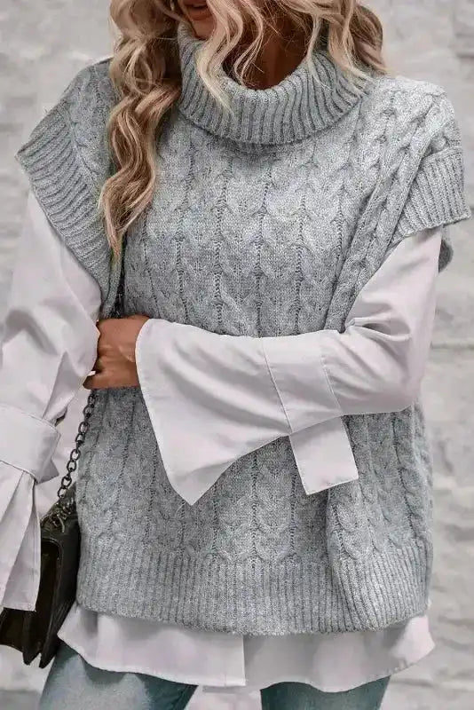 Layered look with grey cable knit turtleneck jumper over a flared sleeve blouse. A versatile women's top for fall and winter fashion.
