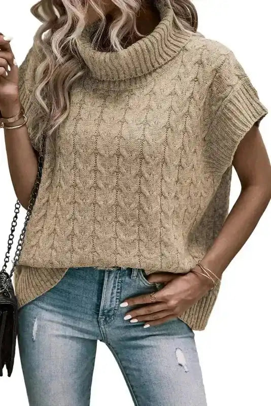 Front view of beige cable knit turtleneck short sleeve jumper. A modern and casual women’s top perfect for layering in cooler seasons.