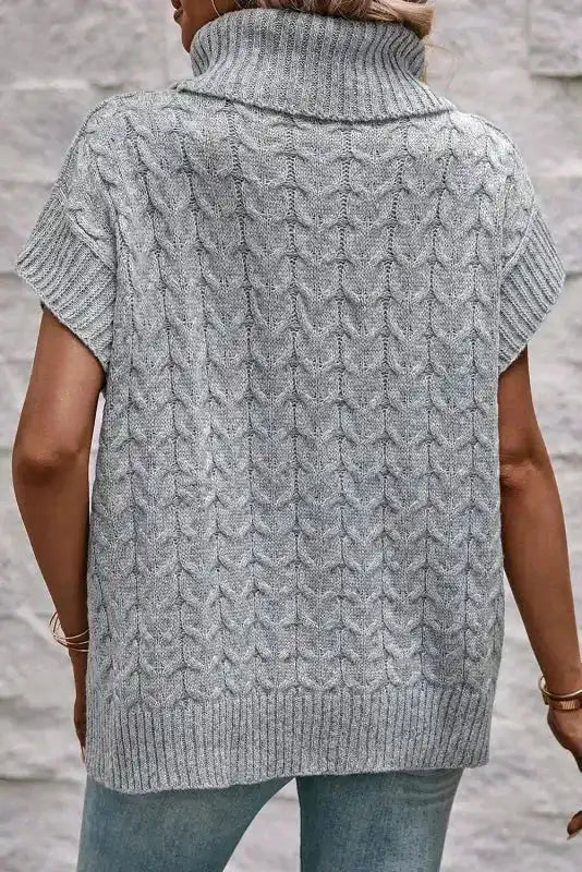 Back view of grey cable knit turtleneck short sleeve jumper. Features ribbed hem and sleeves for a cozy, wrinkle-resistant fit.