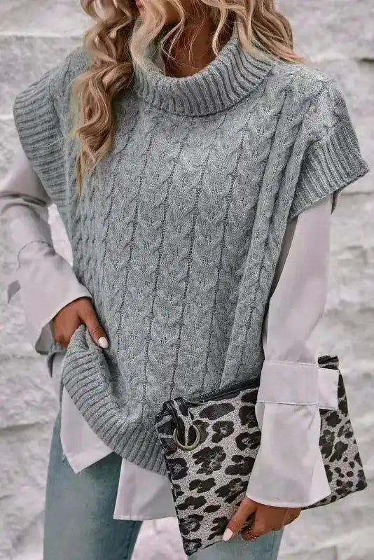 Grey cable knit turtleneck short sleeve jumper layered over a white blouse. Ideal women's knitwear for autumn smart casual outfits.