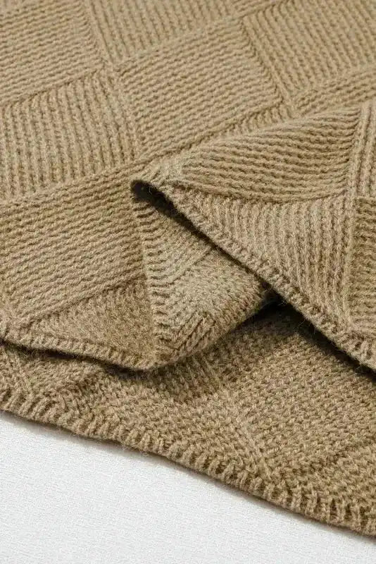 Detailed view of hem and checkered knit pattern on Camel Batwing Sleeve Sweater, emphasizing craftsmanship and texture.