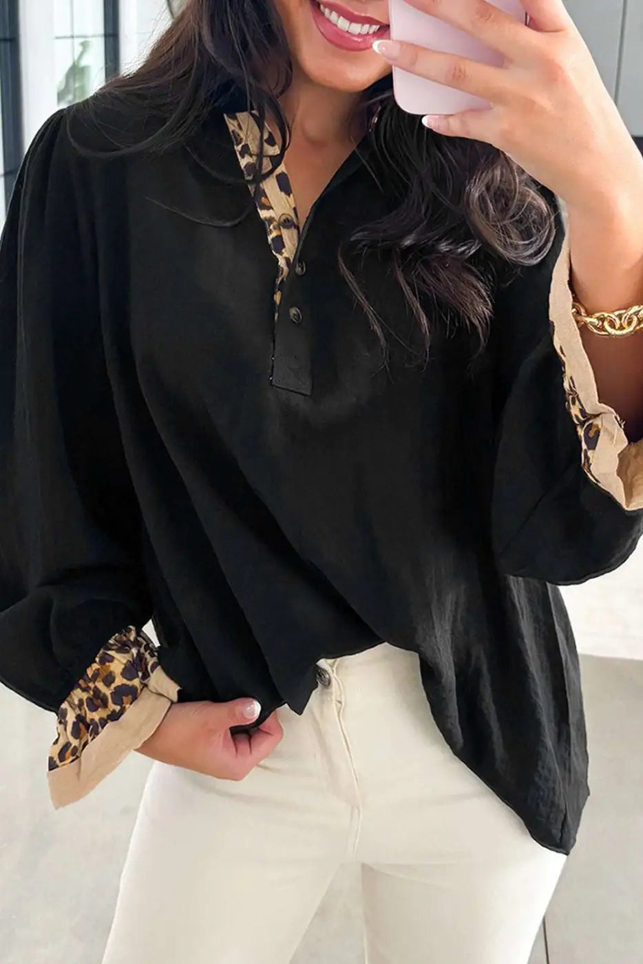 Black version of Camel Leopard Fusion Polo Blouse styled with white pants, featuring leopard print accents and ruffle sleeves.