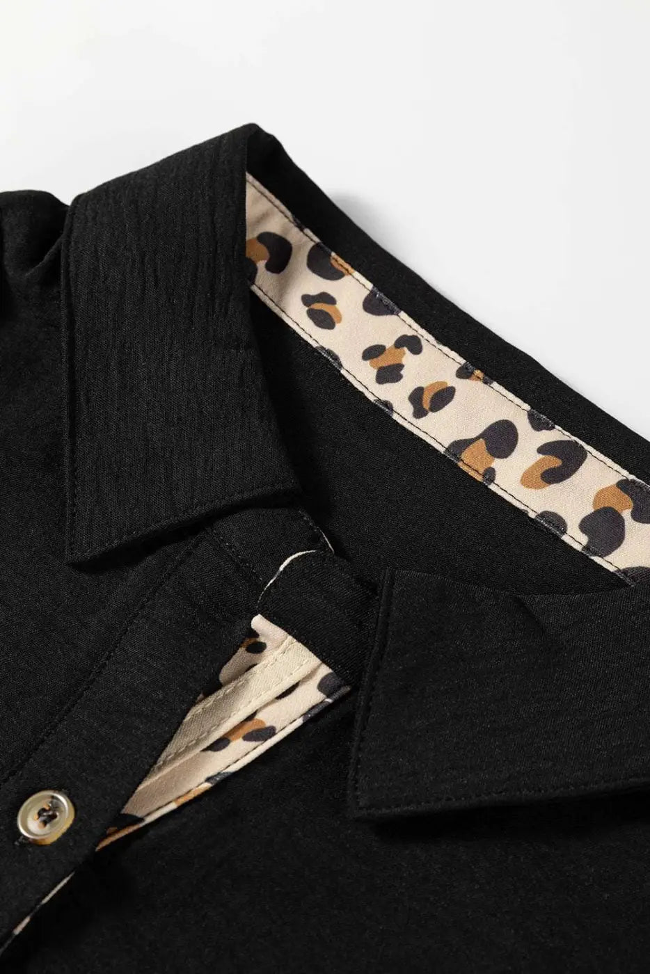 Collar and button detail of Black Camel Leopard Fusion Polo Blouse with leopard print lining, emphasizing its stylish contrast design.