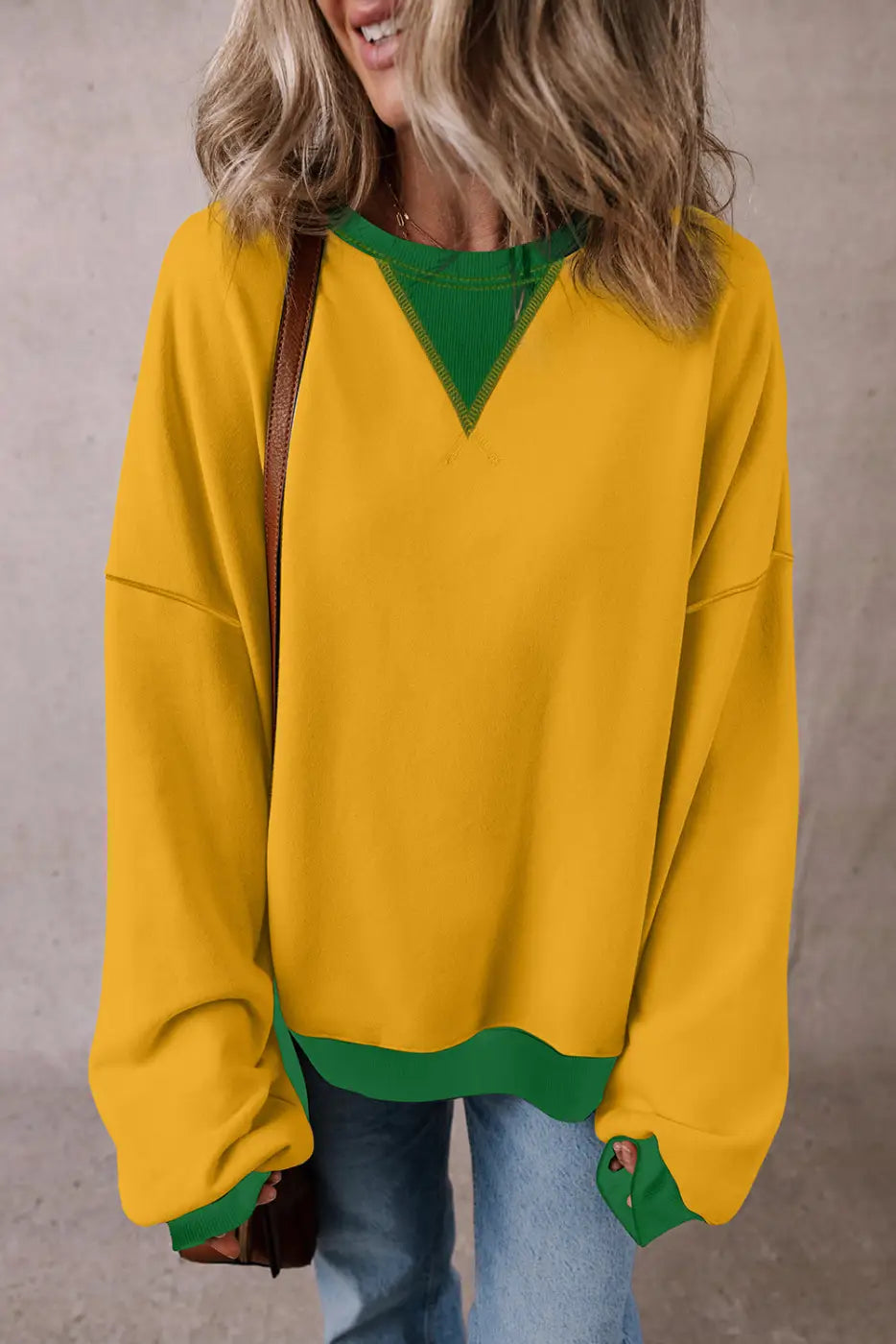 Bright yellow casual oversized sweatshirt with green accents at neckline and cuffs
